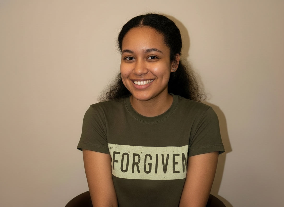 Person wearing a green t-shirt with 'FORGIVEN' printed on it against a plain background