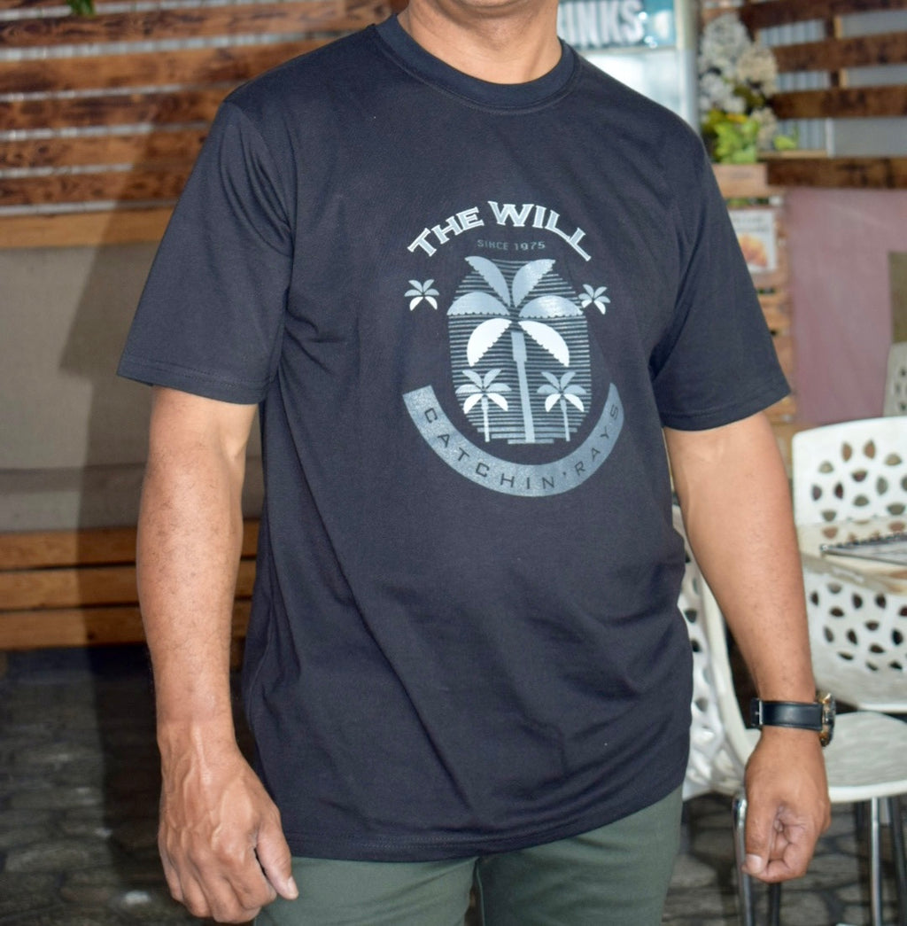 Person wearing a navy blue t-shirt with a palm tree design and text.