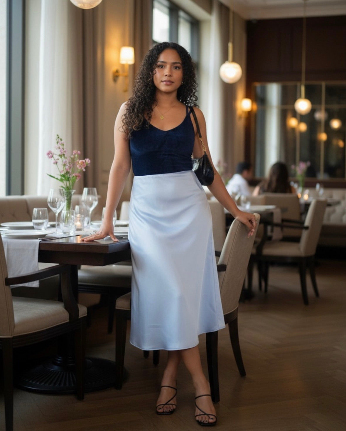 Woman standing in a restaurant with tables and chairs in the background