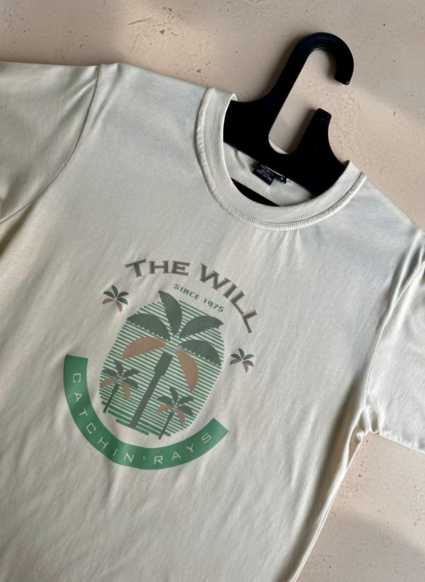 White t-shirt with a palm tree design and text on a marble surface