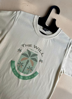 White t-shirt with a palm tree design and text on a marble surface