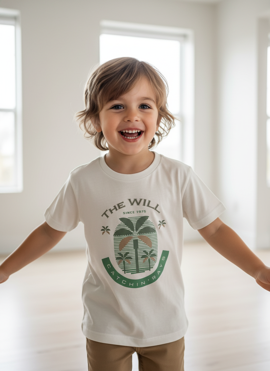 Child wearing a white t-shirt with a green logo and text, standing in a bright room.