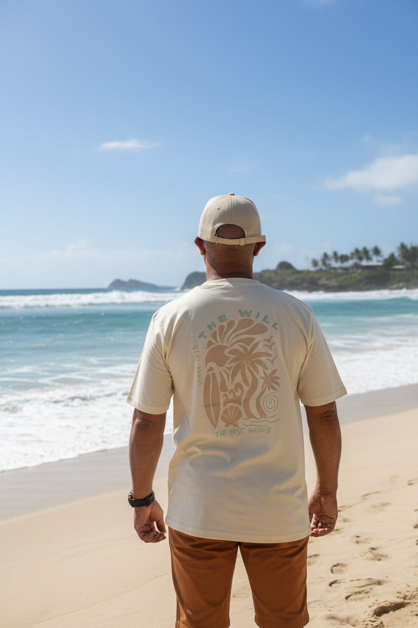 Person wearing a beige shirt with floral patterns and brown pants at the beach