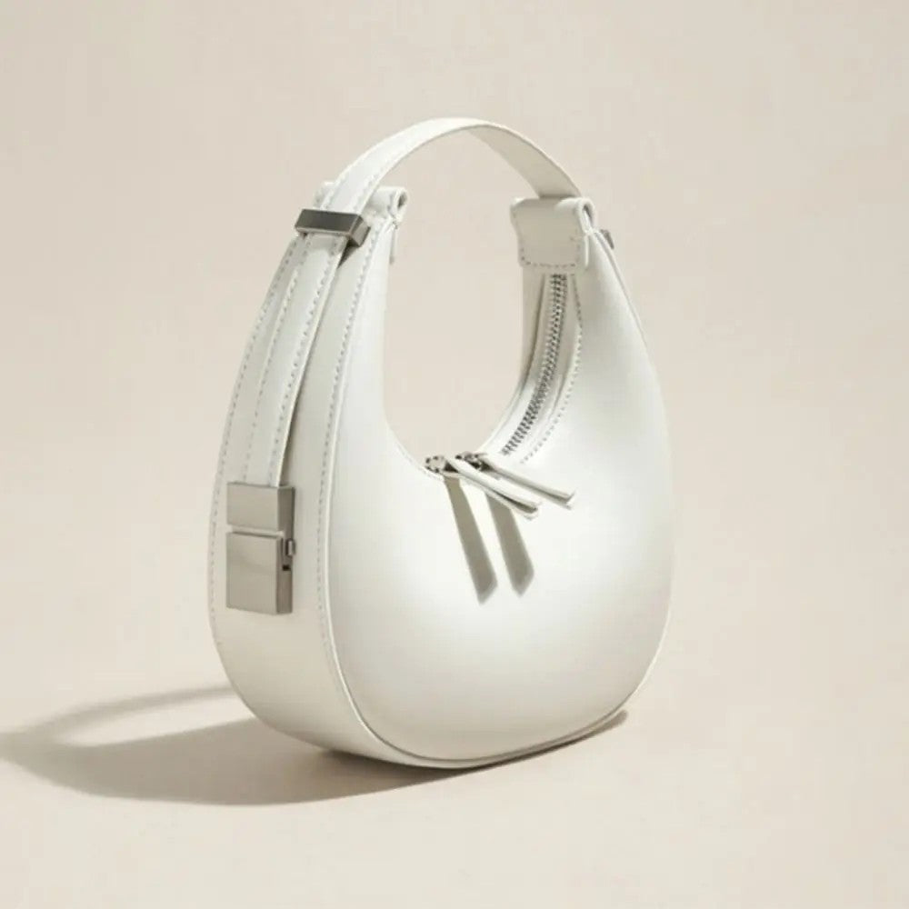 White handbag with silver accents on a beige background