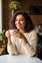 Woman at café wearing She Believed bracelet